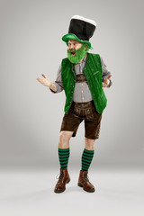 A smiling happy senior man in a leprechaun hat with beard at studio. He celebrates St. Patrick's...