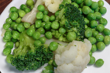 Steamed cauliflower, broccoli and green peas as concept of vegan cuisine. Healthy food lifestyle concept.