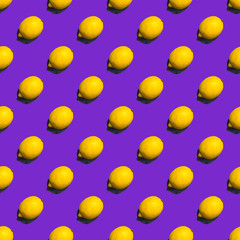 Seamless pattern of lemons on violet background; flat lay