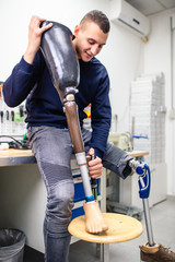 Disabled man working in amputee shop for production prosthetic extremity parts.