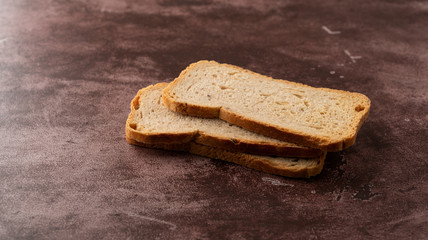 Slices of rye melba toast on a maroon background