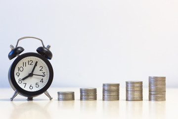 Alarm clock and a pile of coins. concept of profit and business and financial growth