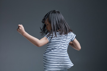 Beautiful cute asian little girl dancing indoors