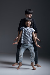 Beautiful cute asian little girl and mother dancing indoors