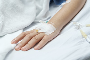 patient hand with saline solution in Intravenous Drip Dropper.