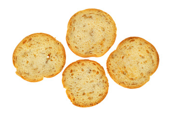 Four pieces of sesame round melba toast isolated on a white background.