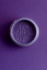jar with pigment fashionable shade ultra violet on a colored background