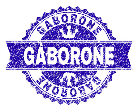 GABORONE rosette stamp watermark with distress texture. Designed with round rosette, ribbon and small crowns. Blue vector rubber watermark of GABORONE title with dirty texture.