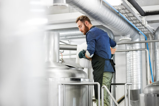 Manufacture, Business And People Concept - Man Working At Craft Brewery Or Beer Plant