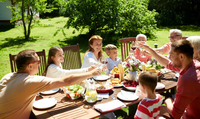 leisure, holidays and people concept - happy family having festive dinner or summer garden party and celebrating