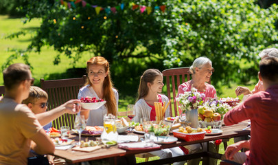 leisure, holidays and people concept - happy family having festive dinner or summer garden party