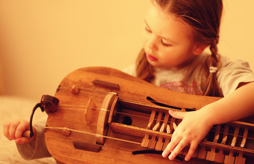 little girl learn to play hurdy-gurdy