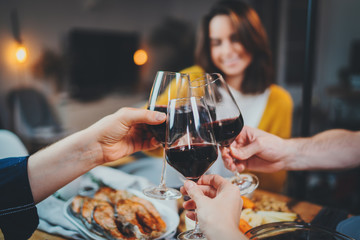 Best friends dining together in cozy home interior, group of people making cheers with glasses of red wine, Celebration Party Cheerful People Concept - obrazy, fototapety, plakaty