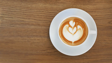 Hot coffee cappuccino latte art top view on wooden table background