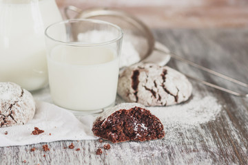 Handmade chocolate cookies, glass and jug with milk, blurred background