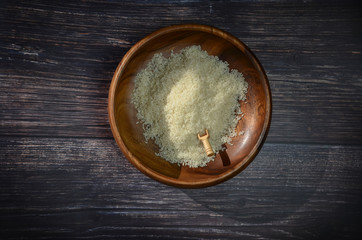 Uncooked dry white rice in wooden bowl on wooden background