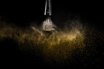 Cosmetic brush with golden cosmetic powder spreading for makeup artist and graphic design in black...