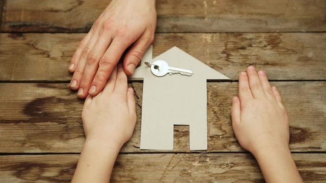 Family house purchase concept. Mother giving key of new home to daughter. 