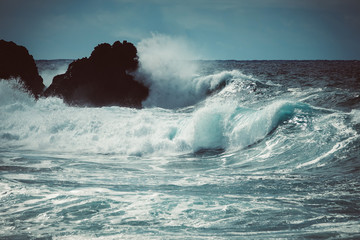 Waves crash along the black lava rock cliffs. Lanzarote, Canary Islands.
