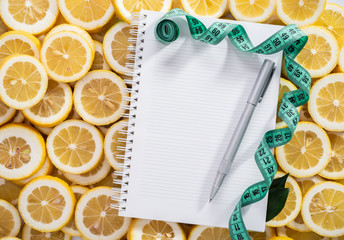 Diet plan concept, lemon slices on notepad, pen and measure tool