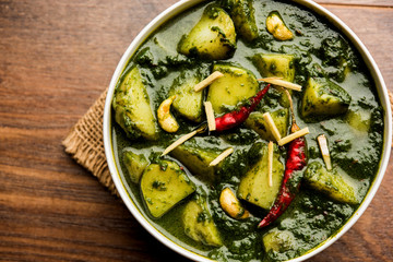 Aloo Palak sabzi or Spinach Potatoes curry served in a bowl. Popular Indian healthy recipe. Selective focus