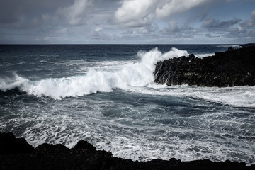 Waves crash along the black lava rock cliffs. Lanzarote, Canary Islands.