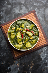 Obraz na płótnie Canvas Aloo Palak sabzi or Spinach Potatoes curry served in a bowl. Popular Indian healthy recipe. Selective focus