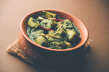 Aloo Palak sabzi or Spinach Potatoes curry served in a bowl. Popular Indian healthy recipe. Selective focus