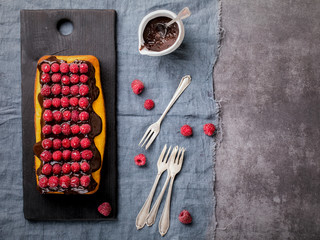 Cheesecake with raspberry poured Chocolate Glaze. Home made buns on a dark background. Pie with Red Berries. Top View. selective focus. Copy space for Text.