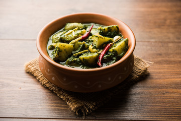 Aloo Palak sabzi or Spinach Potatoes curry served in a bowl. Popular Indian healthy recipe. Selective focus