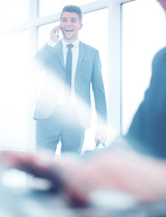 Close-up of workplace in modern office with business people behi