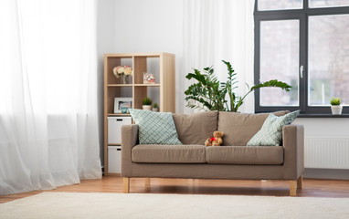 comfort, furniture and interior concept - sofa with cushions at cozy home living room