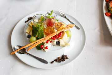 Plate of brie, parmesan, grapes, currants and sauces