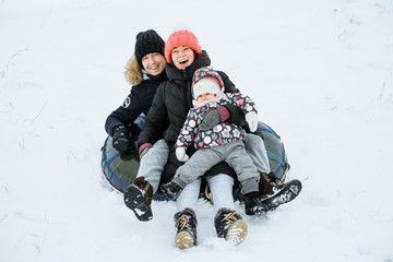 Fototapeta na wymiar Happy family having fun outdoor. Child, mother and father playing in winter time. Active healthy lifestyle concept