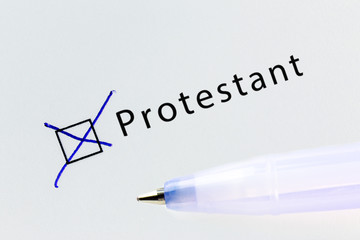 Protestant - checkbox with a cross on white paper with blue pen. Checklist concept.