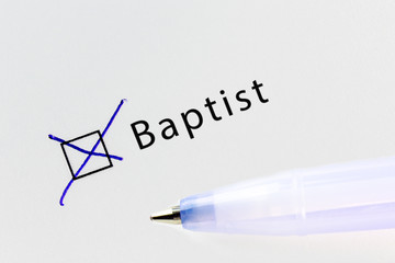 Baptist - checkbox with a cross on white paper with blue pen. Checklist concept.