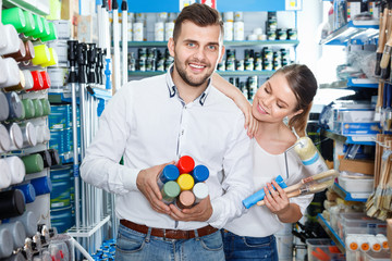Couple standing with  variety  instruments for repair house in the store