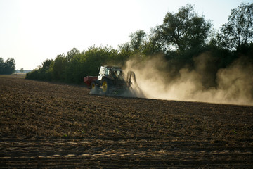 Just before sunset, a farmer was still working on a dusty field 