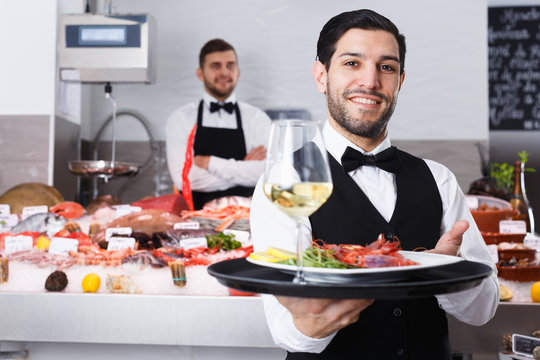 Waiter with serving tray in fish restaurant