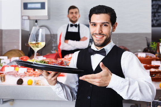 Waiter holding tray with seafood dishes at fish restaurant again