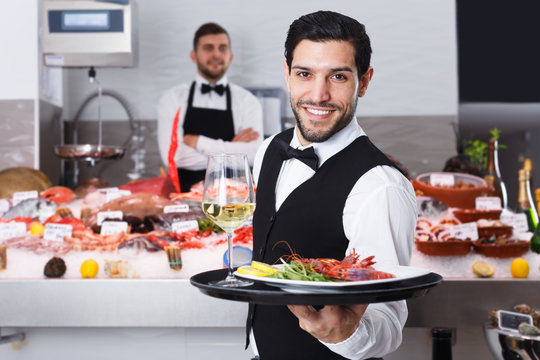 Waiter bringing seafood to guests