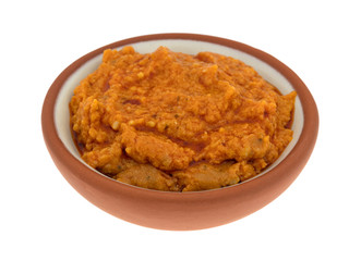 Small bowl of ricotta cheese and tomato pesto on a white background