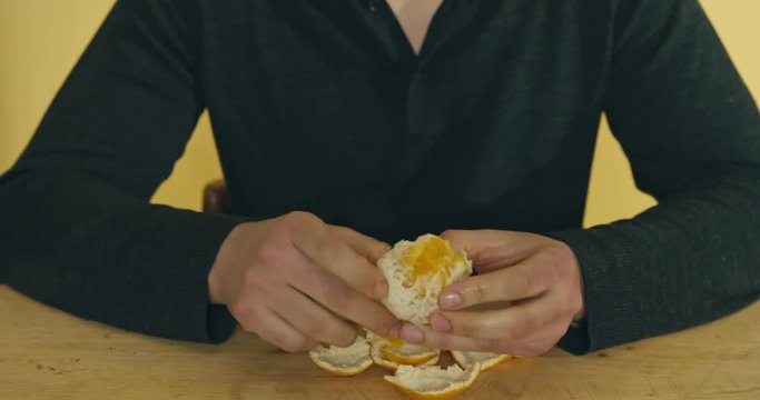Man peeling an orange