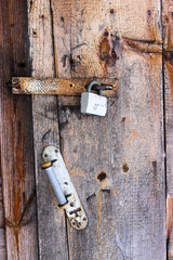 Old door lock on wooden front door.