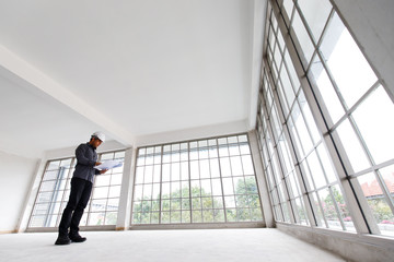 Fototapeta premium Engineer is checking the blue print and underconstruction room