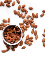 Natural background made in nuts. White background with bowl of almonds.