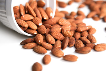 Natural background made in nuts. White background with bowl of almonds.
