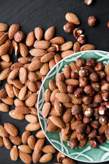 Natural background made in nuts. Almonds on black background.