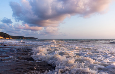 sea landscape is a pebbly beach with waves in white foam