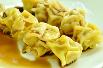 Chinese dumpling stabbing wooden stick dressing soy sauce on plate